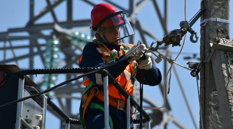 shallow focus photo of man fixing steel cable