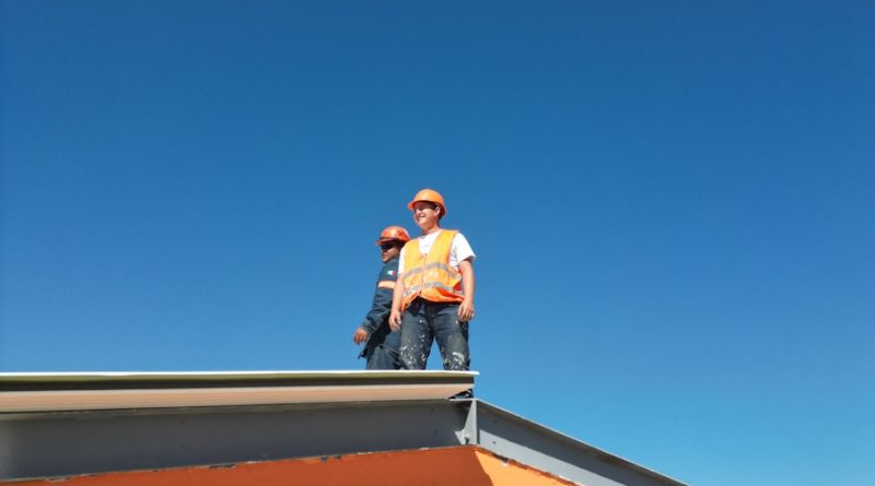 A man standing on top of a skateboard ramp
