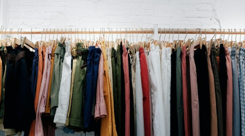 assorted-color clothes lot hanging on wooden wall rack