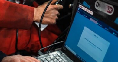 A man sitting in a car using a laptop computer