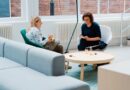 two woman sits on sofa chairs inside house