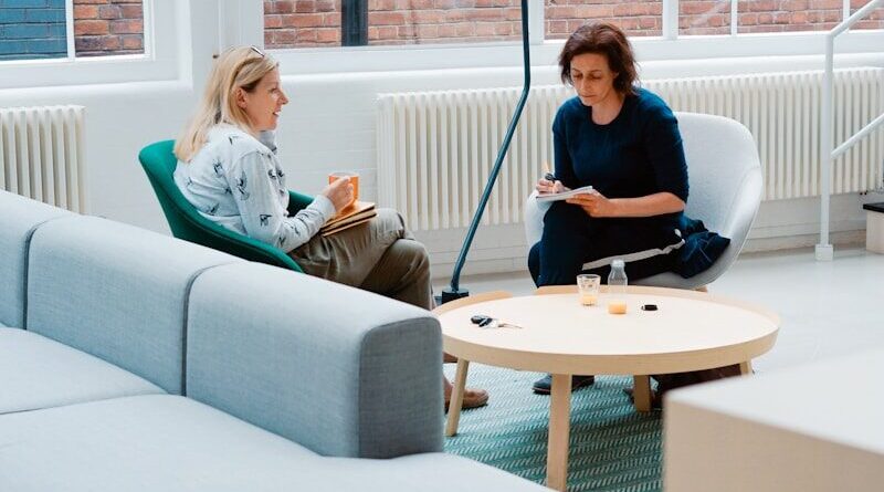 two woman sits on sofa chairs inside house